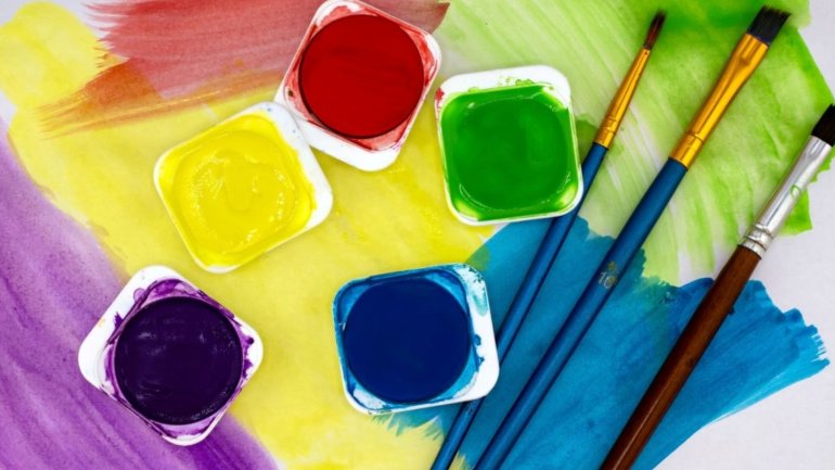 Una tauleta d'aquarel·les de diferents colors i pinzells