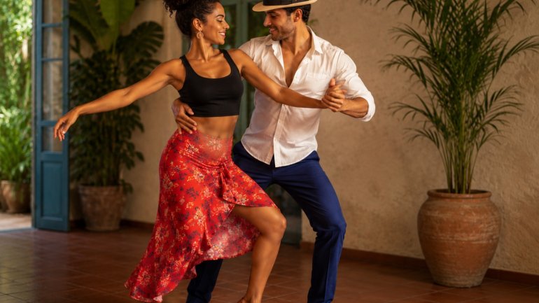 Parella ballant salsa cubana en una sala de ball.