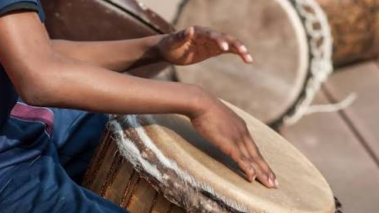 foto de perfil d'una persona tocant un djembe on només se li veuen les mans
