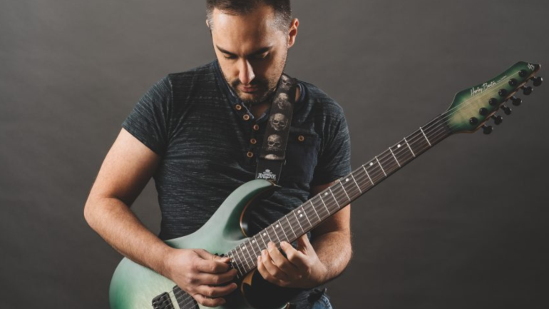 home de cara tocant una guitarra elèctrica